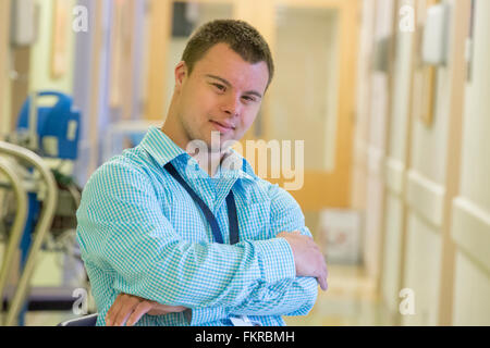 Caucasian man with Down Syndrome working in hospital Stock Photo