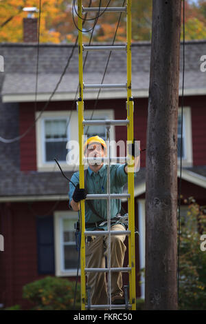 Caucasian worker climbing ladder Stock Photo