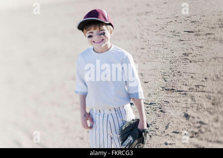 Caucasian boy smiling on baseball field Stock Photo