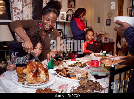 Mother and daughter carving turkey at holiday dinner Stock Photo