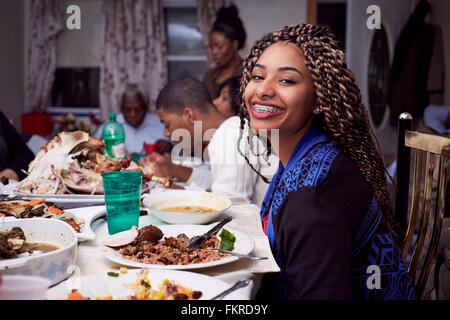 Teenage girl smiling at dinner table Stock Photo