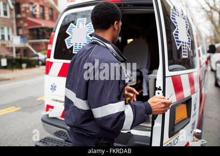 Mixed race paramedic opening ambulance Stock Photo