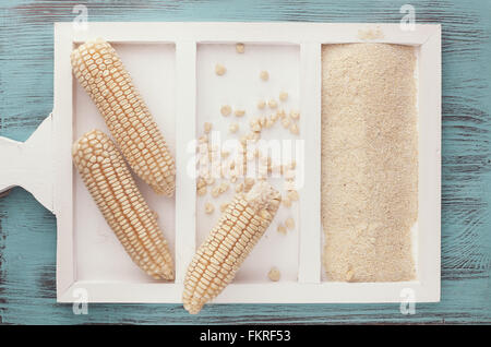 Dried white corn on the cob and corn flour on rustic background. Top view, blank space, vintage style Stock Photo