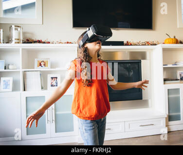 Mixed race girl using virtual reality goggles Stock Photo