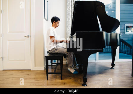 Mixed race boy playing piano Stock Photo