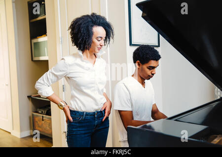Mother watching son play piano Stock Photo