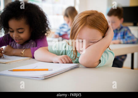 Frustrated student working in classroom Stock Photo