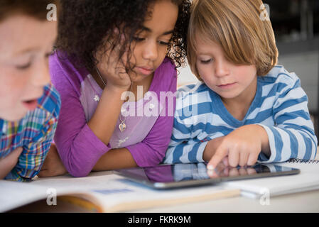 Students using digital tablet in classroom Stock Photo