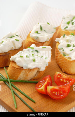 close up of crunchy croutons with chives spread on wooden cutting board Stock Photo