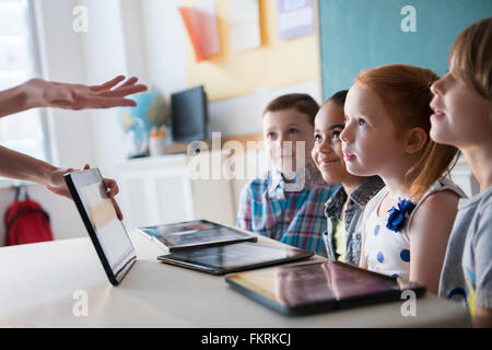 Teacher demonstrating digital tablet for students Stock Photo