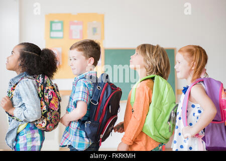 Students wearing backpacks in classroom