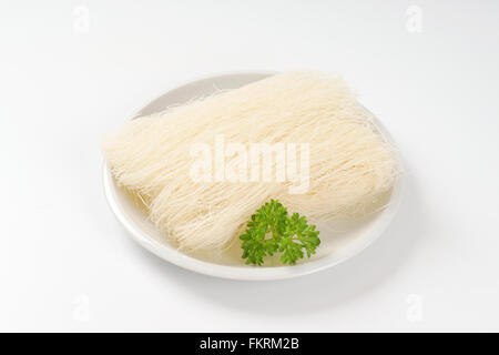 plate of uncooked rice noodles on white background Stock Photo