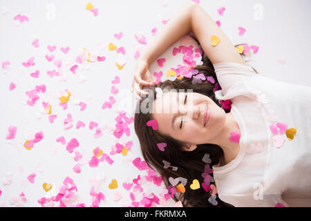 Mixed race woman playing in confetti Stock Photo