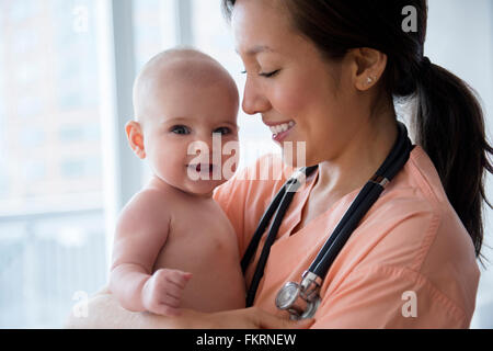 Nurse holding baby girl in hospital Stock Photo