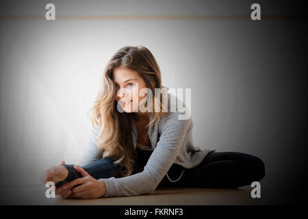 Mixed race dancer stretching in studio Stock Photo