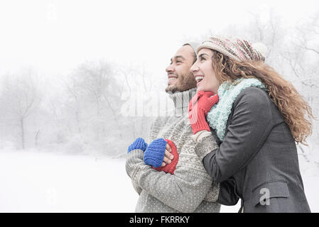 Couple hugging in snow Stock Photo