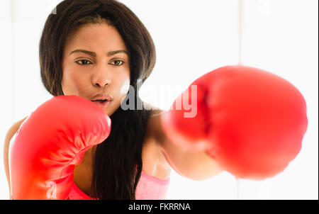 Mixed race boxer punching Stock Photo