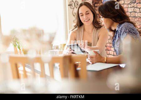 Women using digital tablet in coffee shop Stock Photo