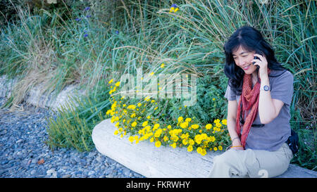 Japanese woman talking on cell phone outdoors Stock Photo