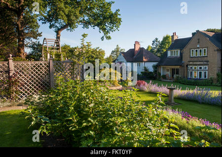 Summer sun & blue sky over Arts and Crafts house - designed, landscaped, beautiful, traditional garden, Burley-in-Wharfedale, West Yorkshire, England. Stock Photo