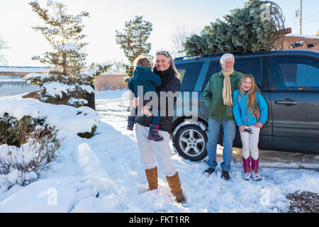 Caucasian family smiling in snow Stock Photo