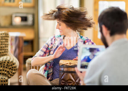 Hispanic man recording girlfriend playing drums Stock Photo