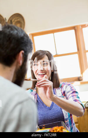 Hispanic woman serving boyfriend in kitchen Stock Photo