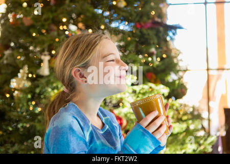 Caucasian girl drinking hot cocoa at Christmas