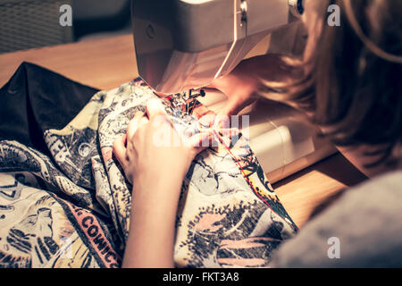 Caucasian woman using sewing machine Stock Photo