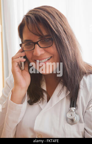 Hispanic doctor talking on cell phone Stock Photo