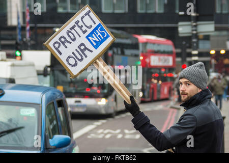 London, England. 10th Mar 2016. 'Protest our NHS'  a picket waves placard on the picket line at St.Thomas’ Hospital, London during the 3rd strike by Junior Doctors. David Rowe/Alamy Live News Stock Photo