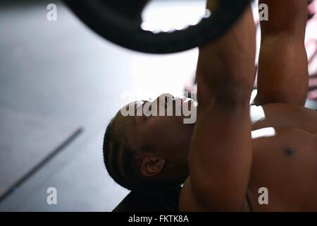 Bodybuilder lifting barbell on floor in gym Stock Photo