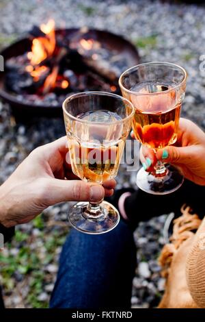 Two people toasting with drinks in wine glasses Stock Photo