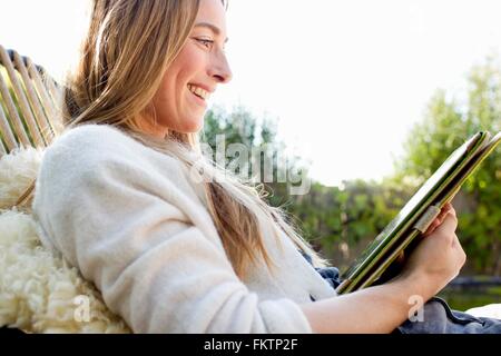 Portrait   mid adult woman using digital tablet, smiling Stock Photo