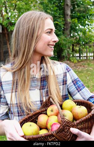 Mid adult woman holding basket   homegrown apples