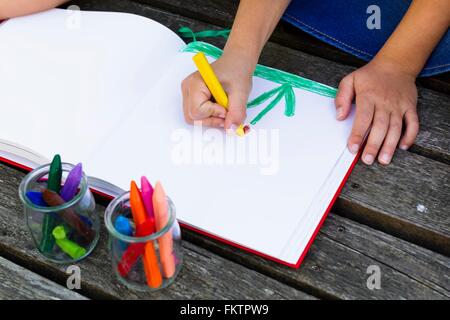 Girl drawing picture in notebook Stock Photo