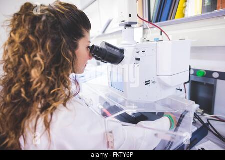 Female scientist using FTIR spectrophotometer, looking at thin film sample through the FTIR microscope Stock Photo