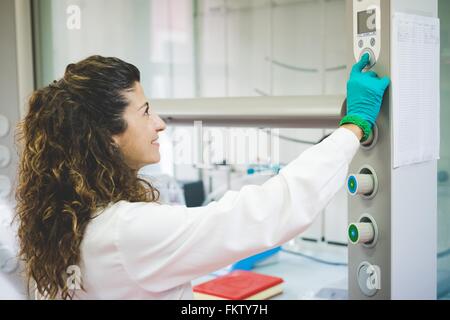 Female scientist switching on chemical hood Stock Photo