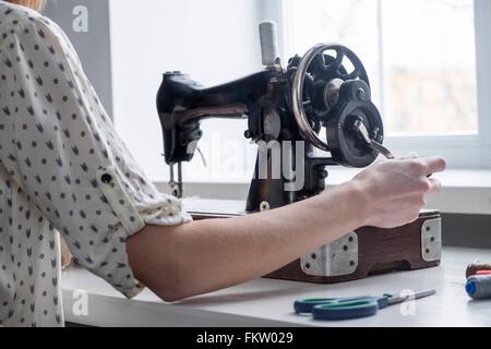 Cropped view of woman using vintage sewing machine Stock Photo