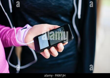 Close up of young womans hand selecting smartphone music Stock Photo