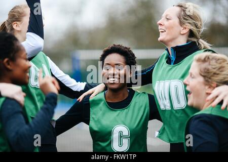 Female netball team celebrating win on netball court Stock Photo