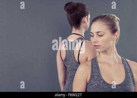 Young women practising yoga, grey background Stock Photo