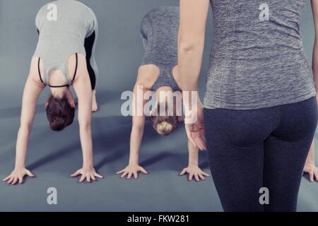 Young women practising yoga, grey background Stock Photo