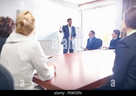 Colleagues in conference room watching presentation Stock Photo