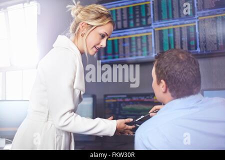 Side view of young business woman in office having discussion with colleague Stock Photo