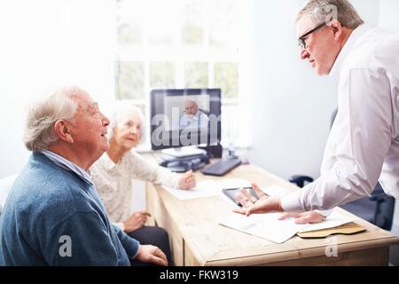 Business man in office having discussion with senior couple Stock Photo