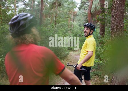 Mountain biking couple taking a break on forest trail Stock Photo