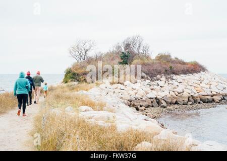 Family walking along pathway beside lake Stock Photo