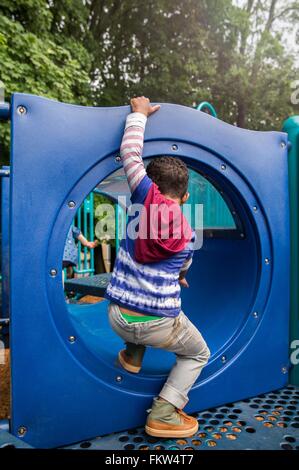 Cute boy playing in a tunnel on playground Stock Photo - Alamy