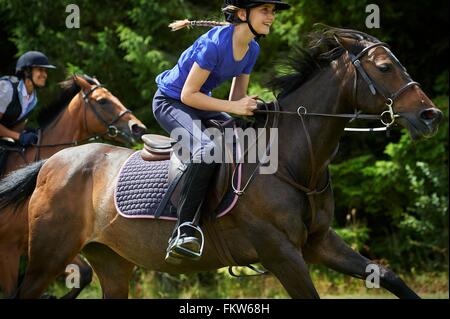 Side view of girl riding horse smiling Stock Photo